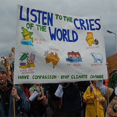 Protesters holding a sign that reads ‘Listen to the cries of the world. Have compassion, stop climate change’